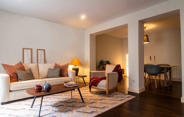 a%20living%20room%20with%20a%20beige%20couch%20and%20warm%20lighting
